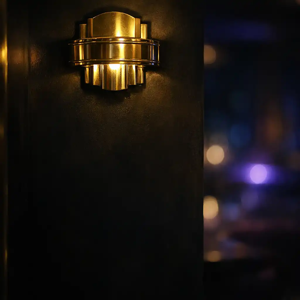Close-up of a brass fixture in the card lounge with ambient light and dark background